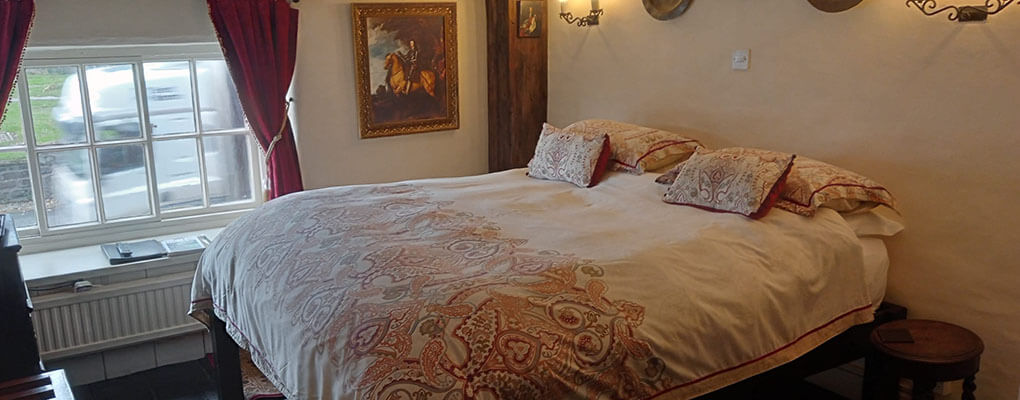 King double bed, ornate black headboard and footer red and gold cushions